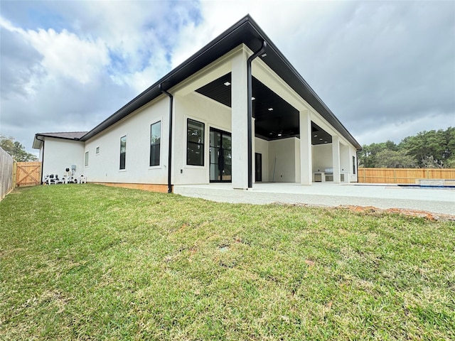 back of house featuring a patio, ceiling fan, and a lawn