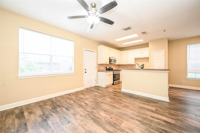 kitchen with dark stone countertops, ceiling fan, white cabinets, and appliances with stainless steel finishes