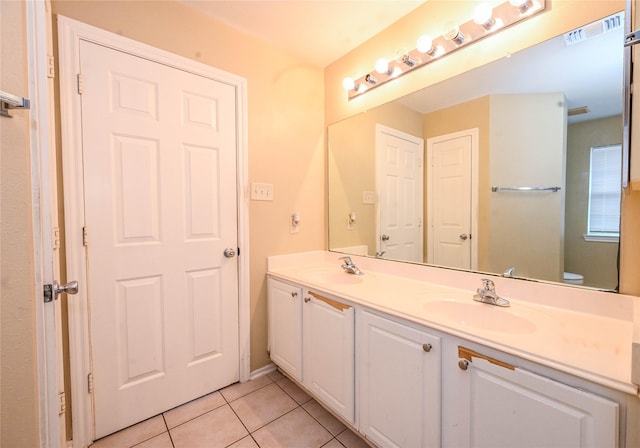 bathroom with tile patterned flooring, vanity, and toilet