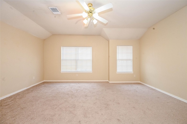 carpeted spare room with vaulted ceiling and ceiling fan