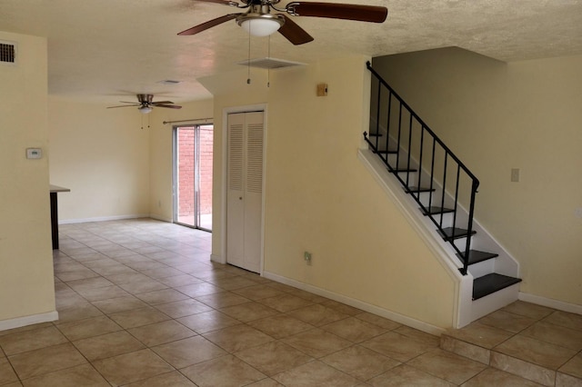 interior space with a textured ceiling and light tile patterned flooring