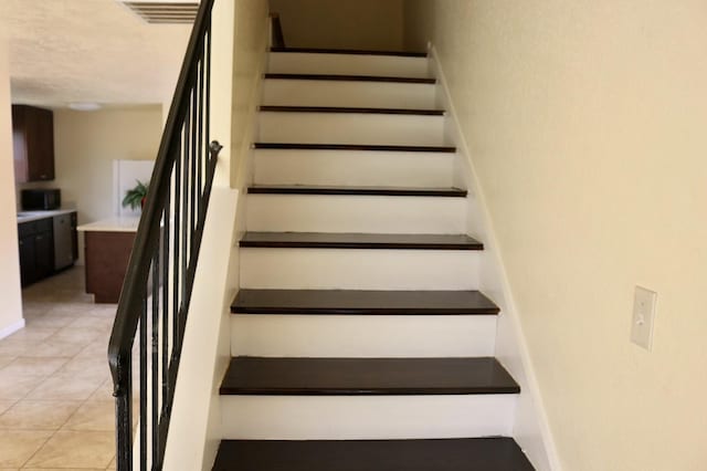 staircase featuring tile patterned flooring