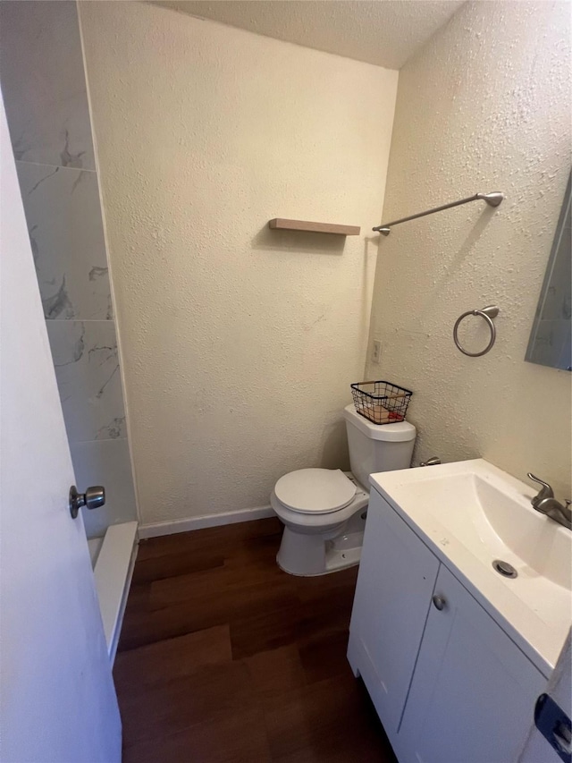 bathroom featuring toilet, vanity, a textured ceiling, and hardwood / wood-style flooring