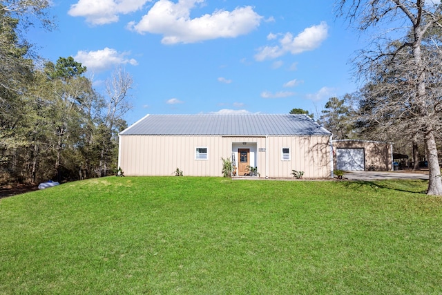 rear view of property with a lawn and a garage