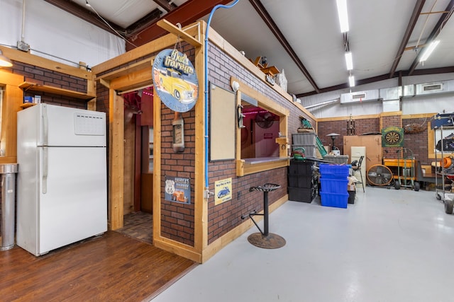 interior space with a workshop area and white fridge