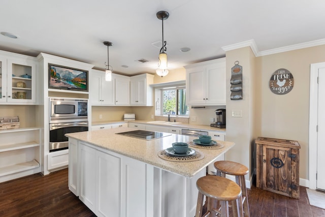 kitchen with sink, light stone counters, hanging light fixtures, appliances with stainless steel finishes, and white cabinets