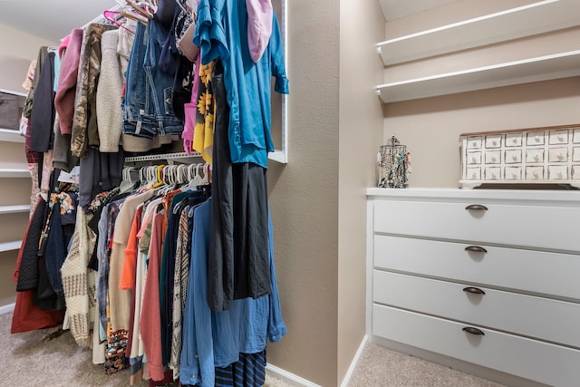 walk in closet featuring light carpet