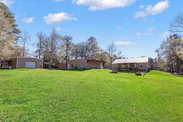 view of yard with a garage and an outbuilding