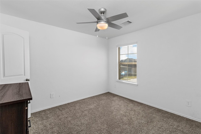 empty room featuring ceiling fan and dark colored carpet