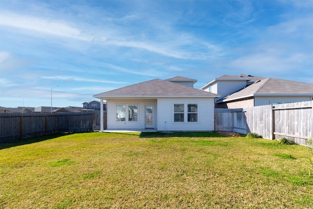 rear view of property featuring a yard