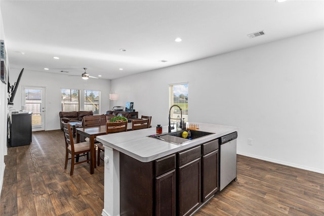 kitchen featuring dark hardwood / wood-style flooring, stainless steel dishwasher, ceiling fan, a kitchen island with sink, and sink