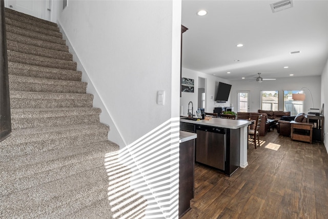 stairway with ceiling fan, sink, and hardwood / wood-style flooring