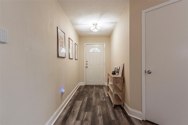 doorway with dark hardwood / wood-style flooring and a textured ceiling