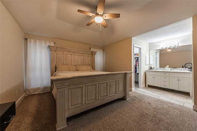 bedroom featuring ceiling fan, a raised ceiling, a spacious closet, light colored carpet, and a closet