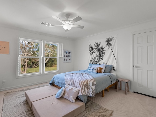 carpeted bedroom with ceiling fan and ornamental molding