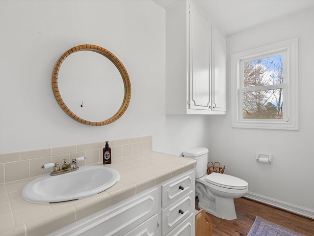 bathroom with hardwood / wood-style flooring, toilet, and vanity