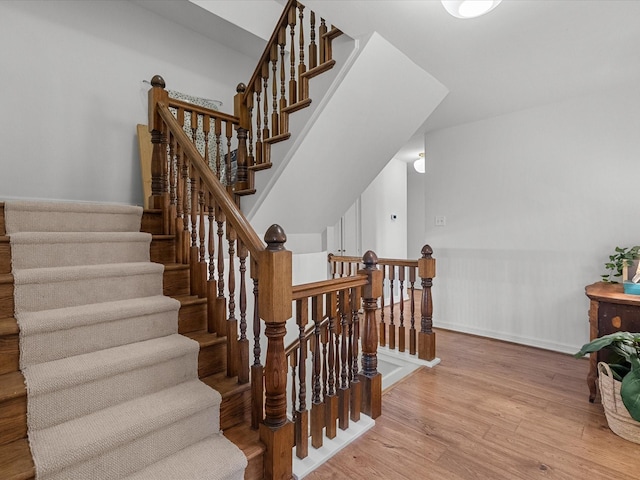 staircase with hardwood / wood-style flooring