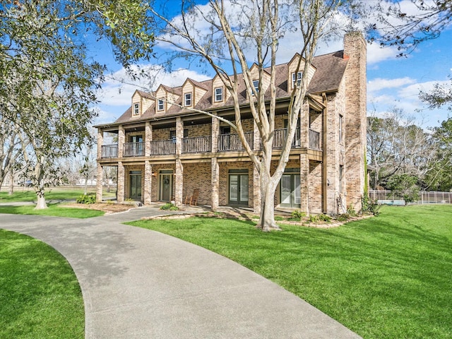 view of front of home featuring a front lawn and a balcony