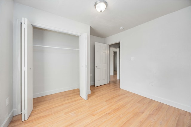 unfurnished bedroom with light hardwood / wood-style floors and a closet