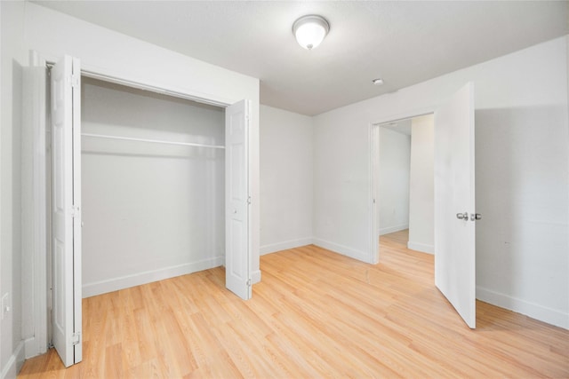 unfurnished bedroom with light hardwood / wood-style floors and a closet