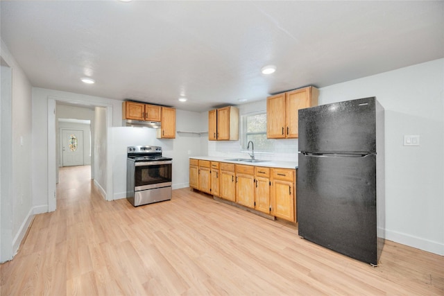 kitchen featuring black refrigerator, electric stove, sink, decorative backsplash, and light hardwood / wood-style floors