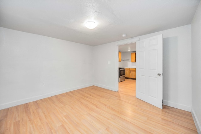 spare room featuring a textured ceiling and light wood-type flooring