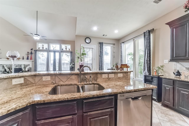 kitchen featuring dishwasher, sink, decorative backsplash, light stone counters, and dark brown cabinetry