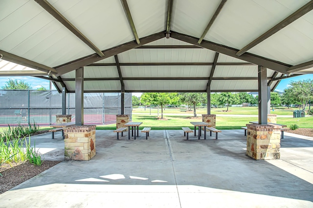 surrounding community featuring a gazebo, tennis court, and a lawn