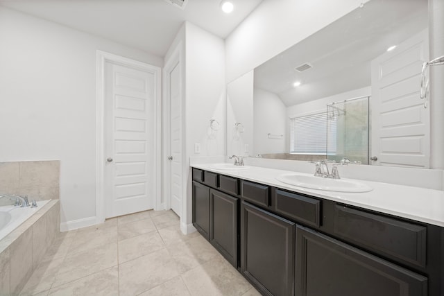 bathroom with plus walk in shower, vanity, and tile patterned flooring