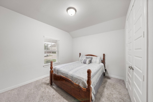 carpeted bedroom with lofted ceiling