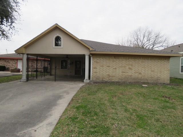 single story home featuring a front yard and a carport