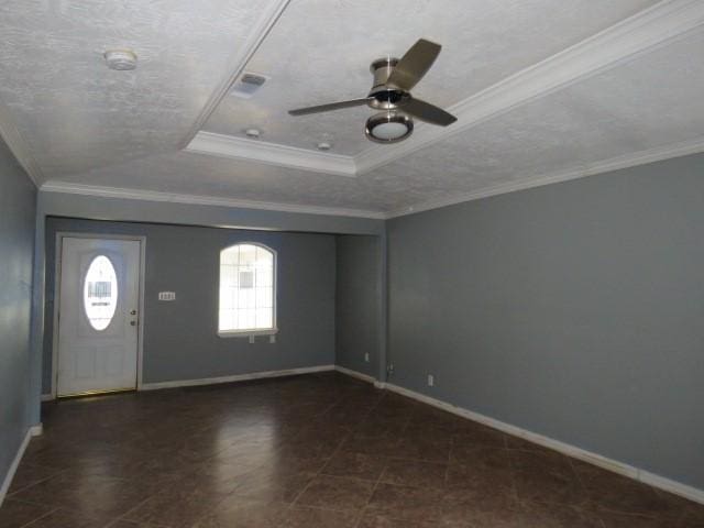 foyer entrance with a textured ceiling, a tray ceiling, ceiling fan, and ornamental molding