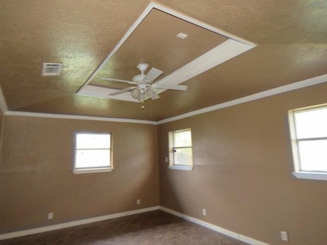 empty room featuring ceiling fan, ornamental molding, carpet floors, and vaulted ceiling