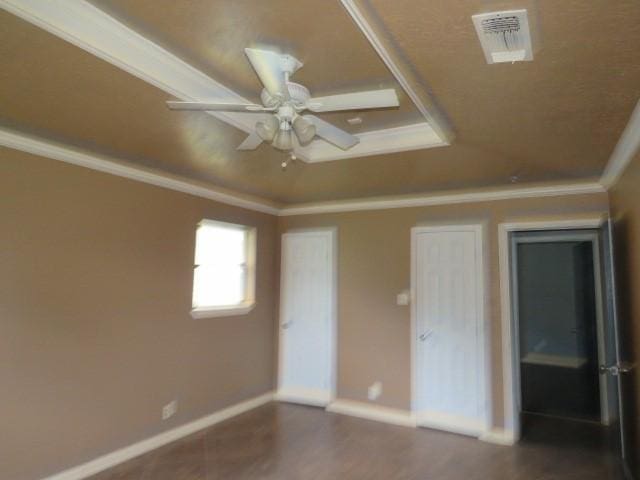 unfurnished room featuring dark wood-type flooring, ceiling fan, and crown molding