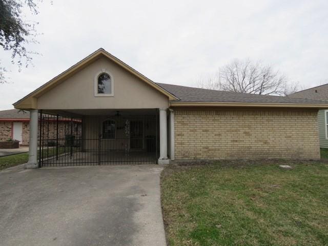 single story home featuring a front lawn and a carport