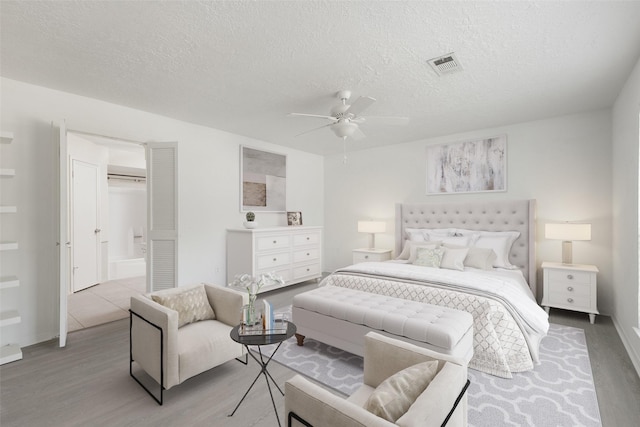 bedroom with a closet, ceiling fan, light hardwood / wood-style flooring, and a textured ceiling