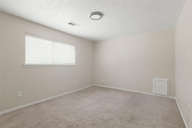 carpeted spare room with a textured ceiling