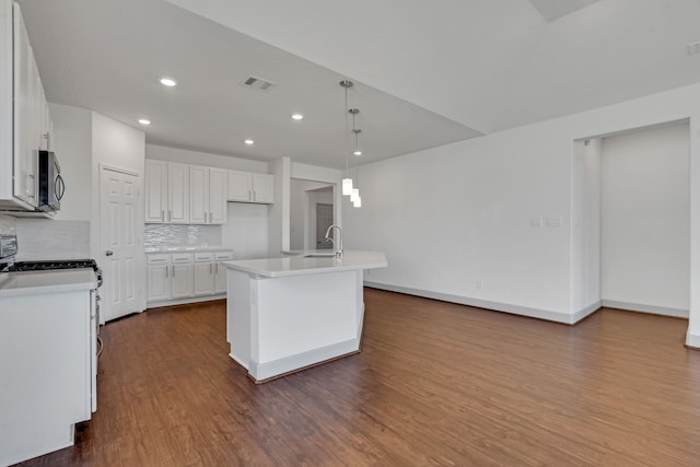 kitchen with white cabinets, backsplash, pendant lighting, and an island with sink