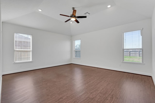 unfurnished room with a tray ceiling, ceiling fan, dark hardwood / wood-style flooring, and lofted ceiling