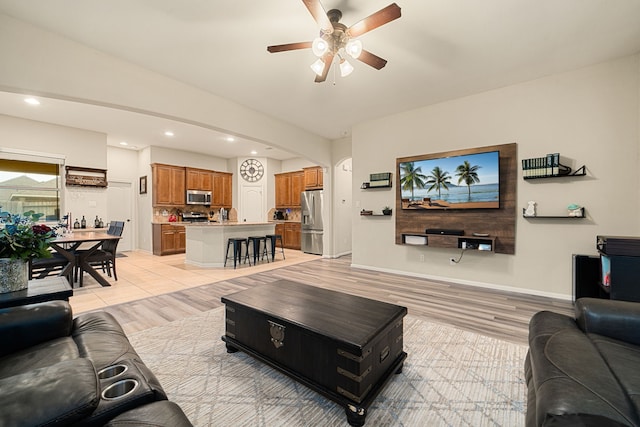 living room featuring ceiling fan and light wood-type flooring