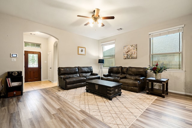 living room featuring a wealth of natural light, ceiling fan, and light hardwood / wood-style flooring