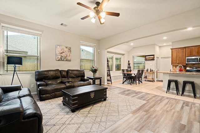 living room featuring ceiling fan, sink, and light hardwood / wood-style floors