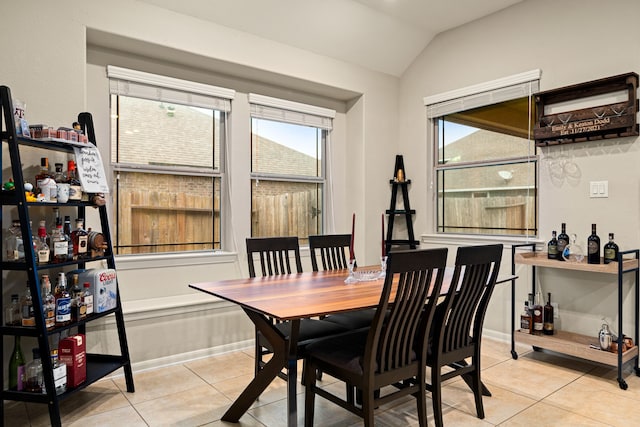 dining area featuring light tile patterned flooring and lofted ceiling