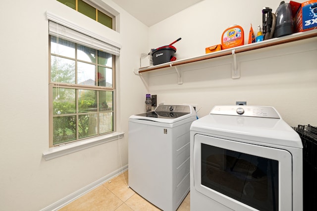 clothes washing area with washer and dryer and light tile patterned flooring