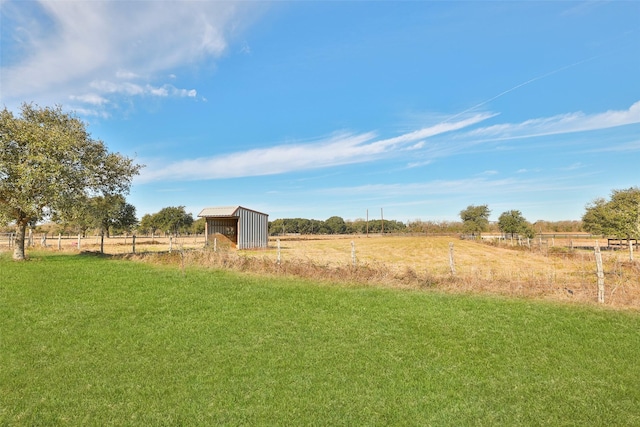 view of yard with a rural view and an outdoor structure