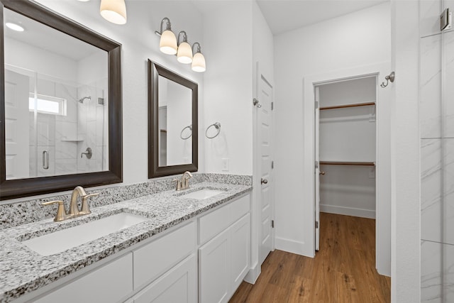 bathroom with walk in shower, hardwood / wood-style floors, and vanity