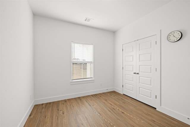 unfurnished bedroom featuring light wood-type flooring and a closet