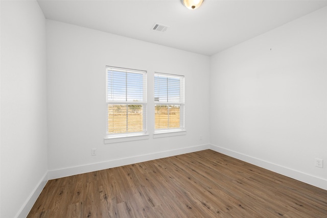 unfurnished room with hardwood / wood-style flooring