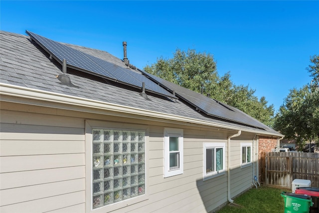 view of side of home featuring solar panels