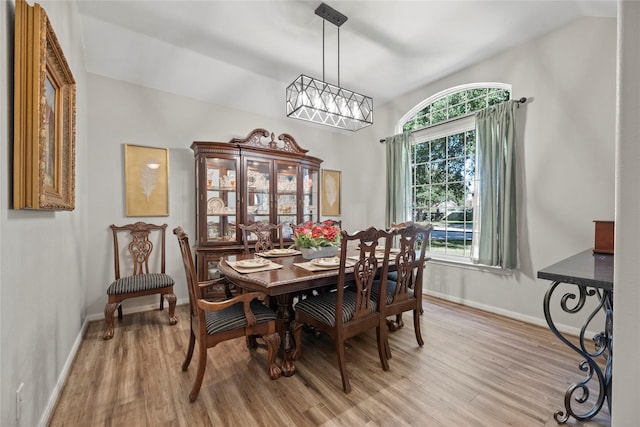 dining area with light hardwood / wood-style floors and lofted ceiling